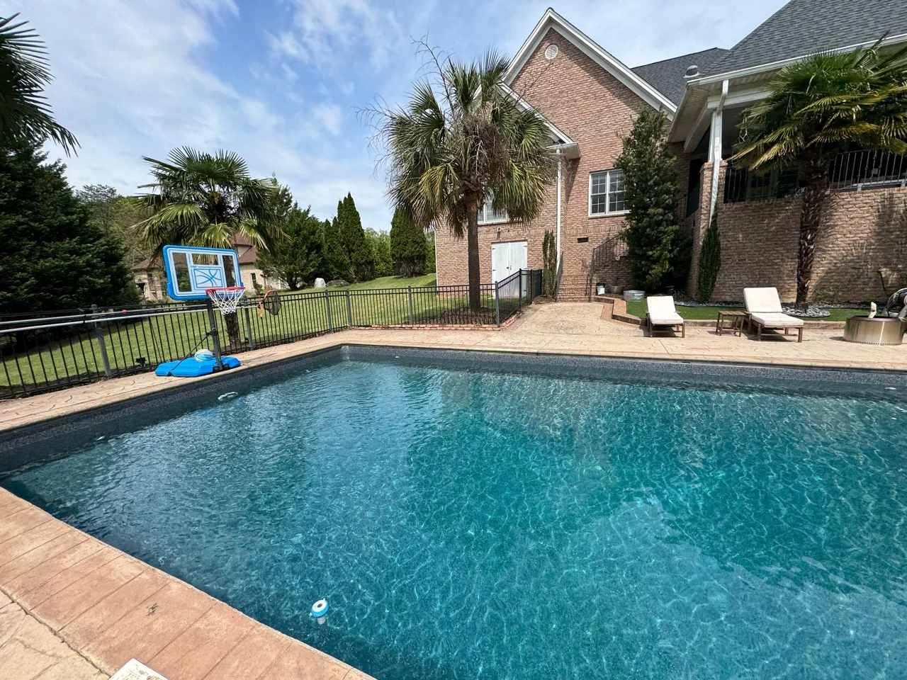 Pool looking toward the brick rear exterior and covered porch